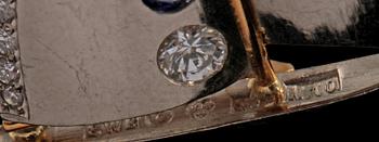BROSCH, 18k guld och vitguld med 17 briljantslipade diamanter tot 0.36 ct och 2 blå safirer 0.21 ct, Göteborg. Vikt 5 g.