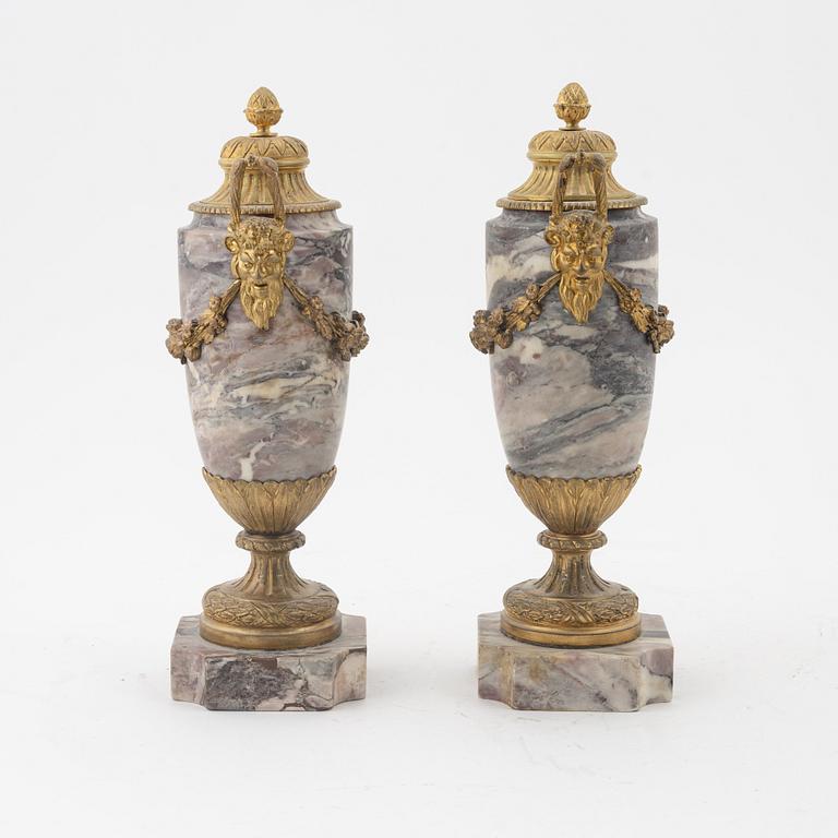 A pair of Louis XVI style urns with covers.