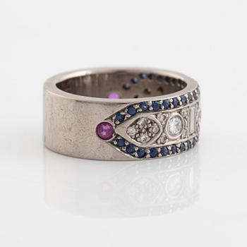An 18K white gold ring set with diamonds, rubies and sapphires.