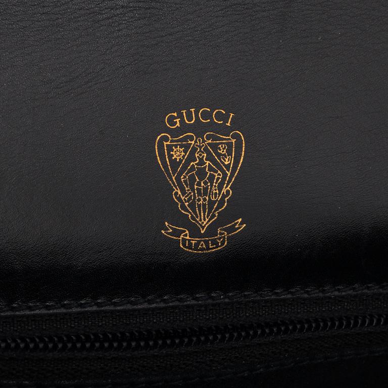 Gucci, a black leather bag.