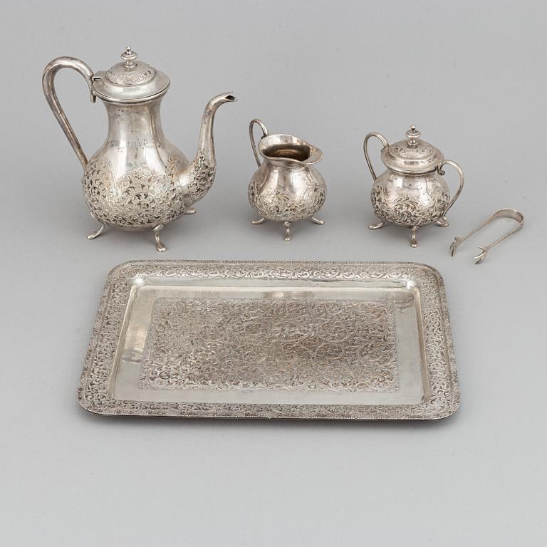 A Pakistan silver coffee pot, sugar bowl, sugar tongs and creamer.