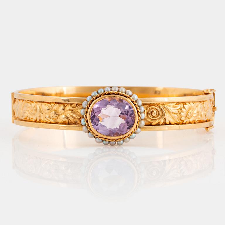 An 18K gold bracelet set with a faceted amethyst and pearls.