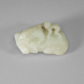 24. A carved white nephrite belt hook of a recumbent horse and a monkey, Qing dynasty (1644-1912).