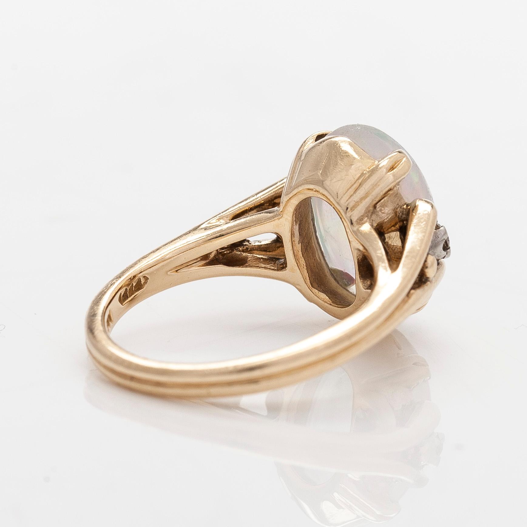 Ring in 14K gold with an oval opal and diamonds.
