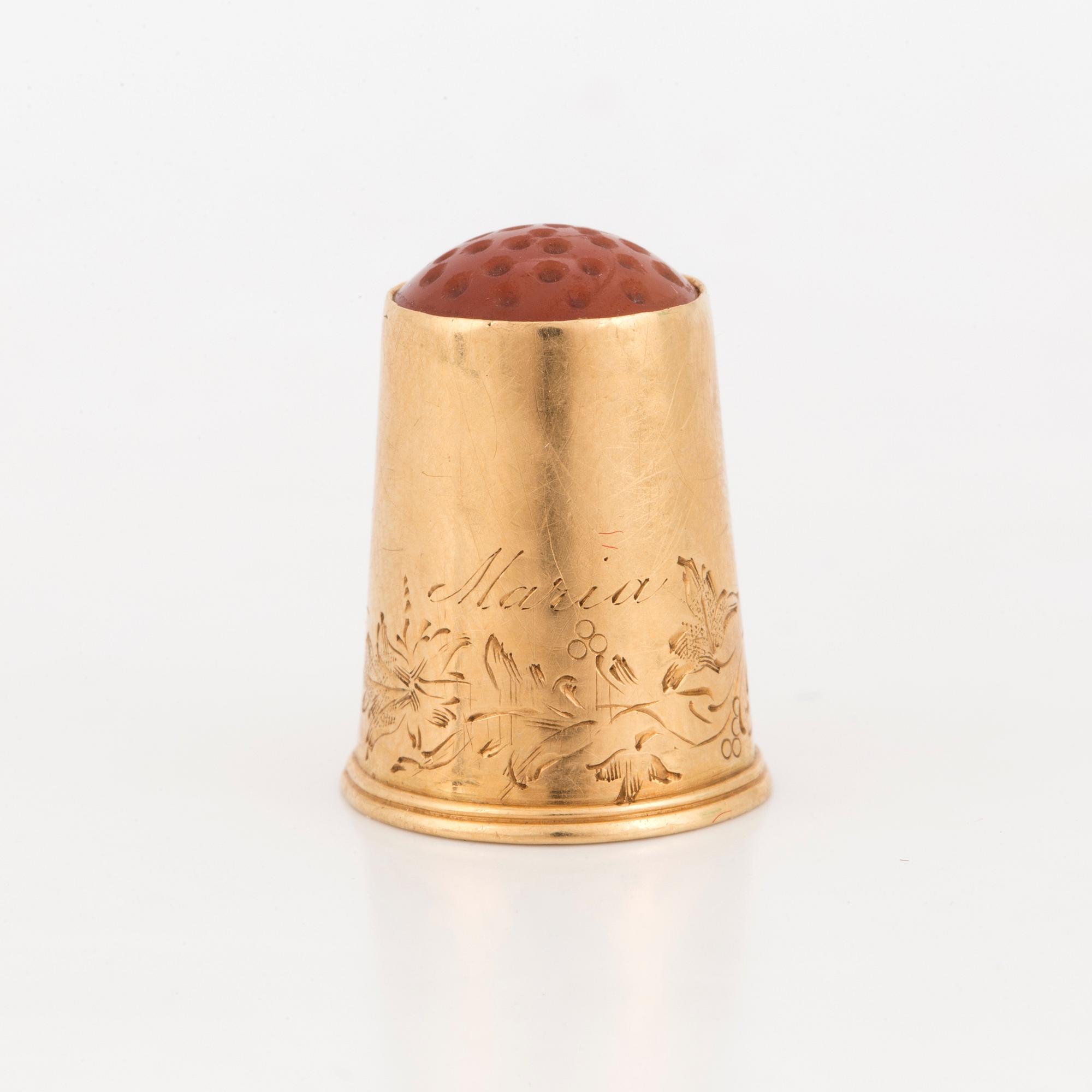 A thimble set with carnelian.