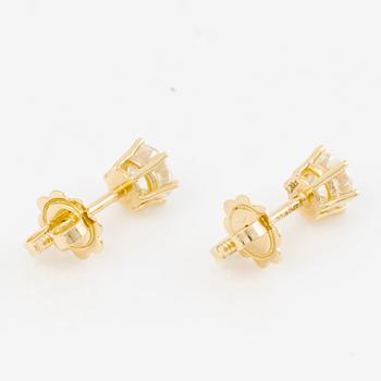 A pair of earrings in 18K gold set with two round brilliant-cut diamonds.