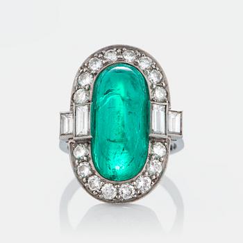 1039. A platinum ring set with a cabochon-cut emerald ca 7 cts and brilliant and baguette-cut diamonds.