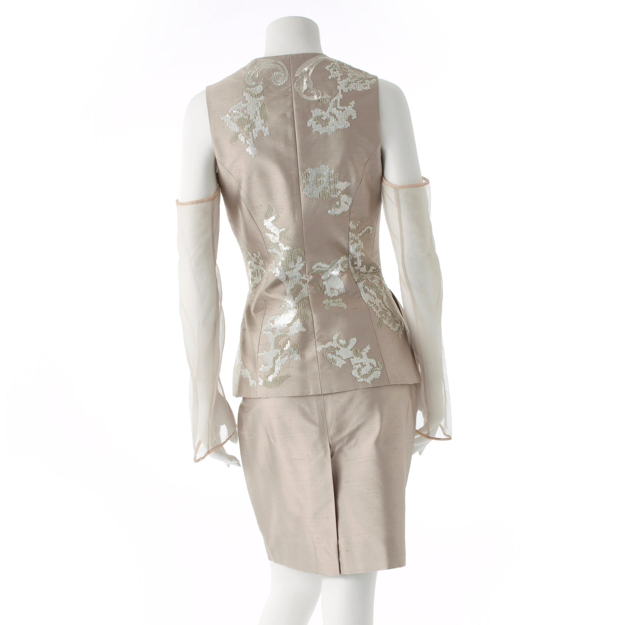GIANFRANCO FERRÉ, a beige three-piece ensemble consisting of vest , trousers and skirt.