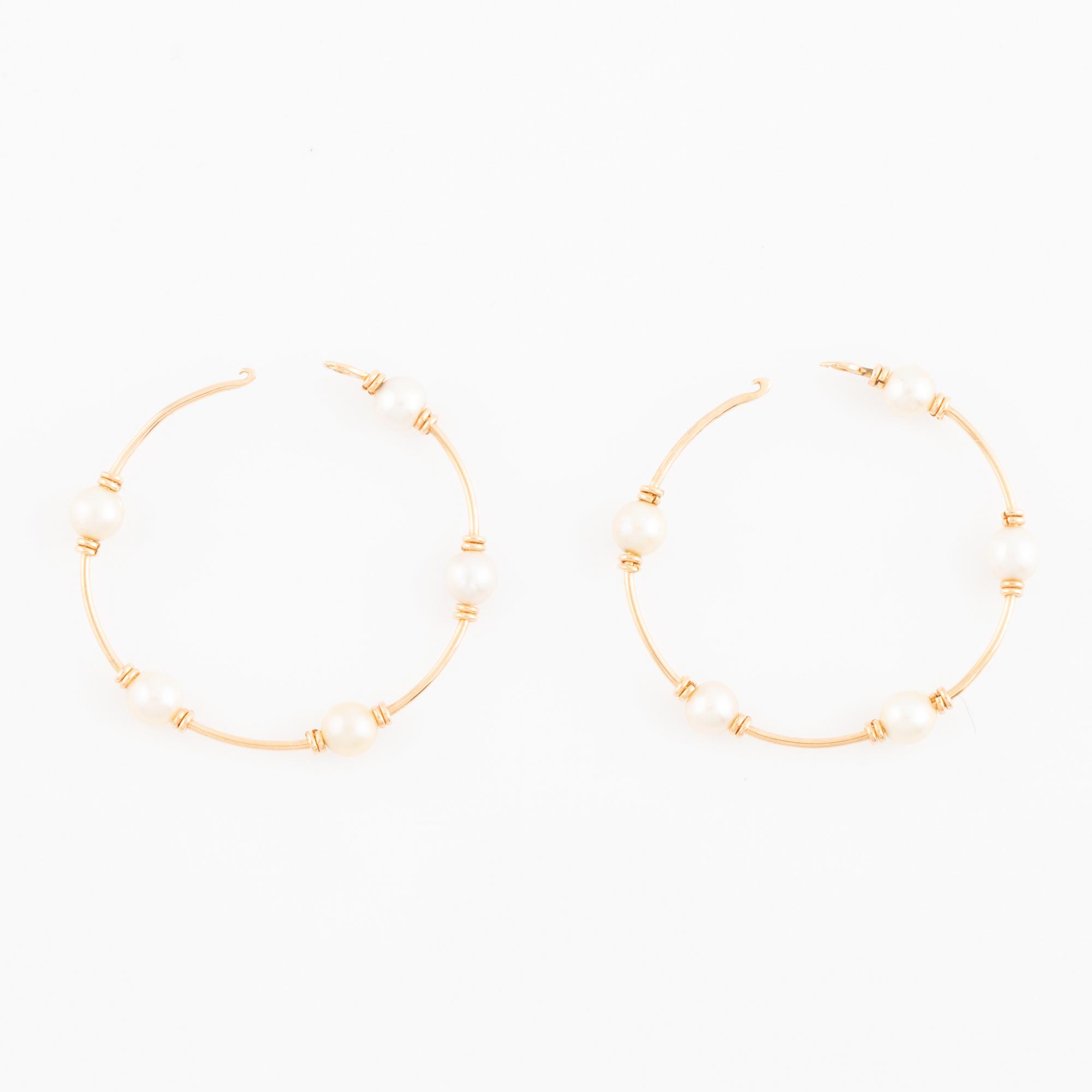 Gold and pearl hoop earrings.