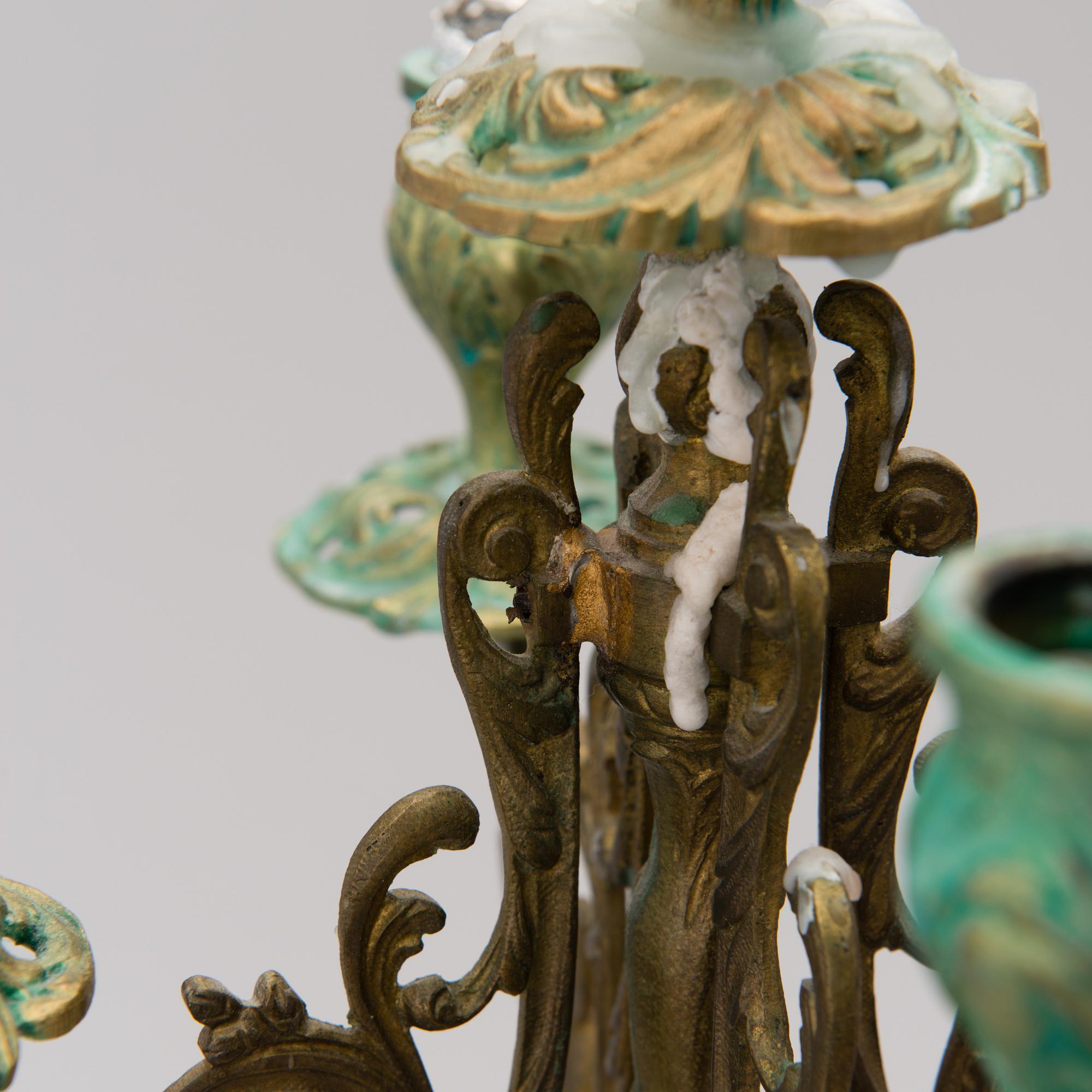 A pair of gilt-bronze Rococo Revival candelabra with porcelain decors, from the latter half of the 19th century.