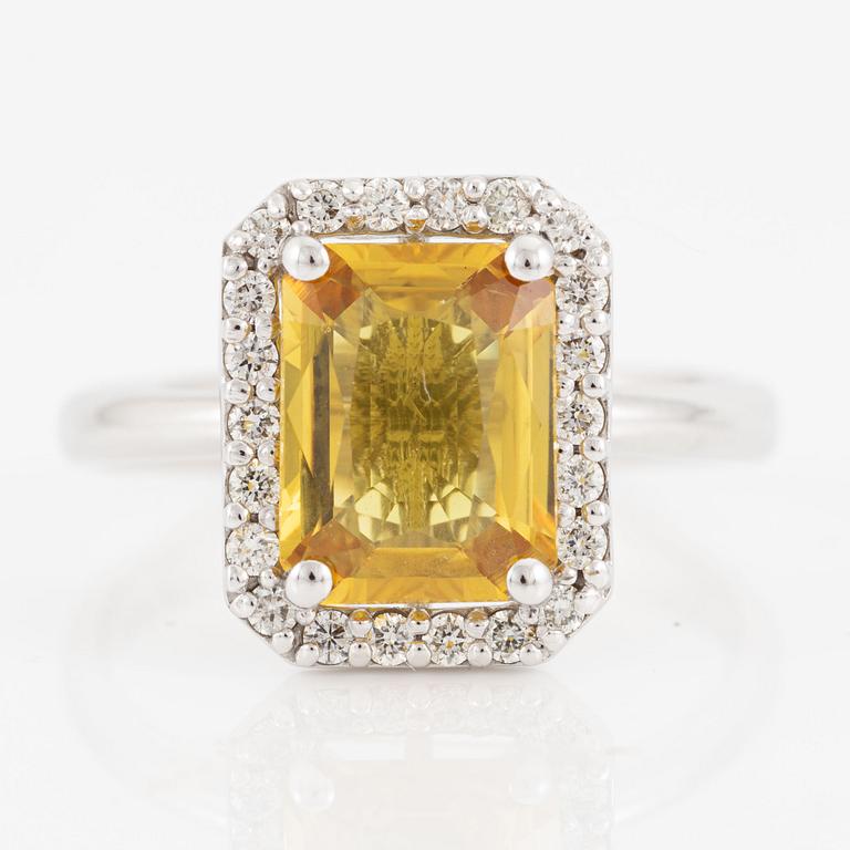 Ring 18K guld med en fasettslipad safir och runda briljantslipade diamanter.