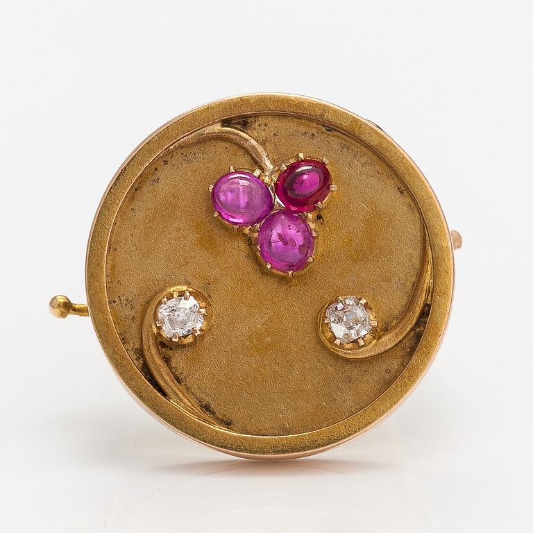 A 14k gold brooch with diamonds ca. 0.12 ct in total and rubies, of which one is synthetic.