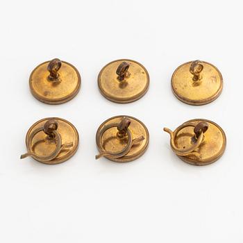 Sex stycken skjortknappar i gul metall med pärlemor och emalj.