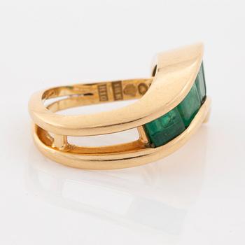 An 18K gold Lantz ring set with step-cut emeralds.