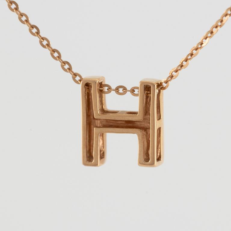 Collier, 18K guld med en berlock av bokstaven H.