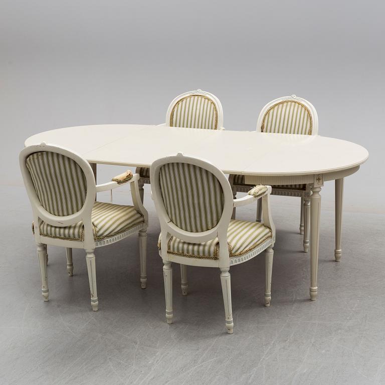 a mid 20th century dining table with four arm chairs.