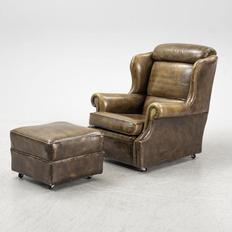 A leather upholstered easy chair with stool, second half of the 20th Century.