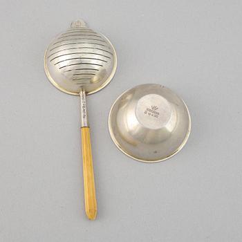 A silver and wood tea strainer by Wiwen Nilsson, Lund, 1932.