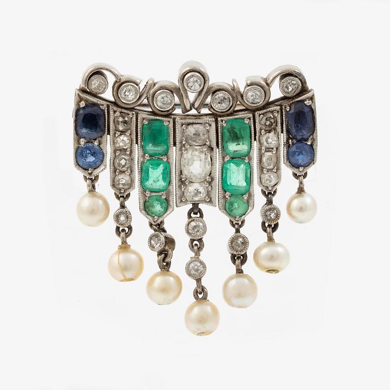 Brooch in platinum set with old-cut diamonds, sapphires, emeralds, and pearls.