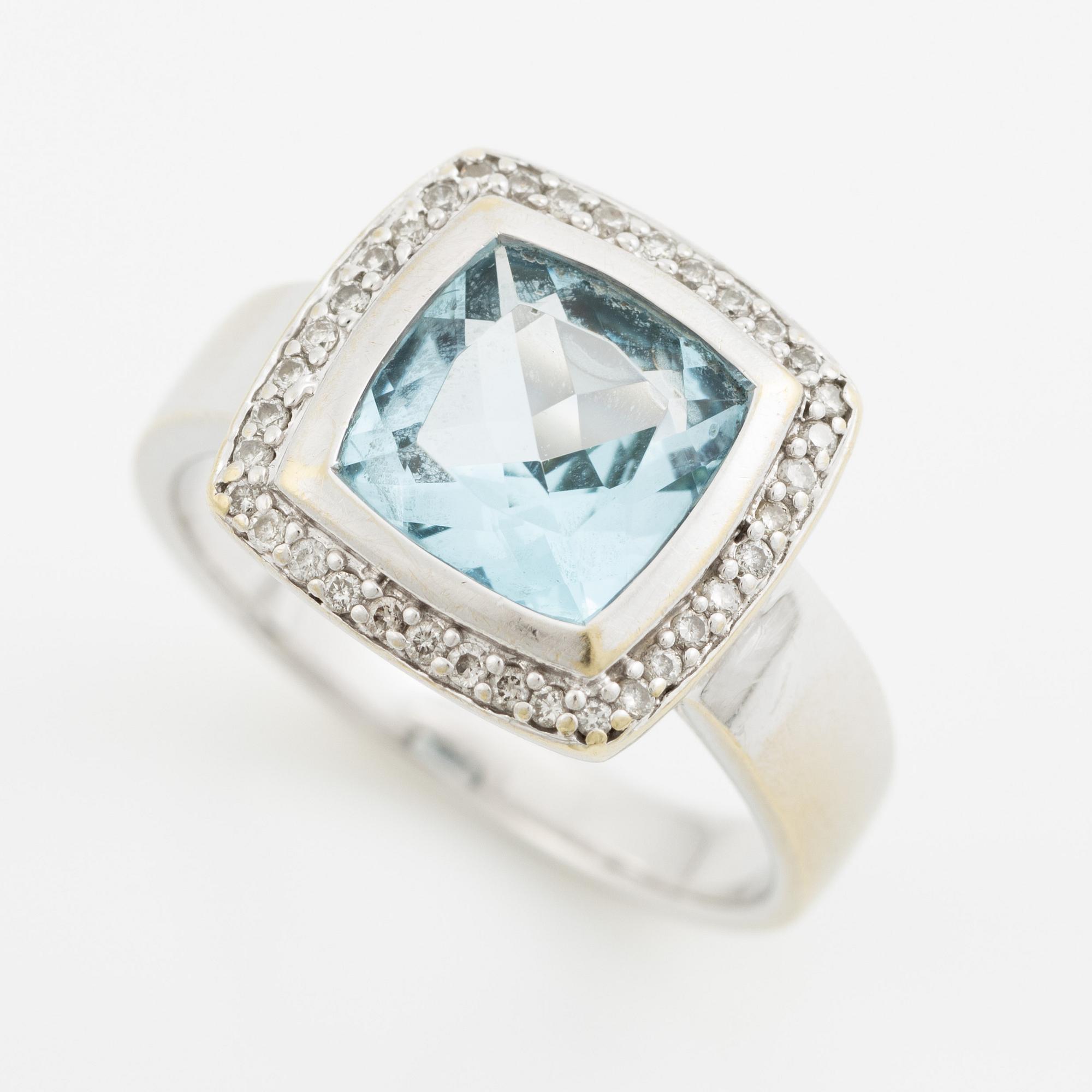 Ring 18K vitguld med en fasettslipad topas och runda briljantslipade diamanter.