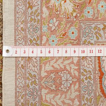 A silk Hereke rug, c. 85 x 55 cm.