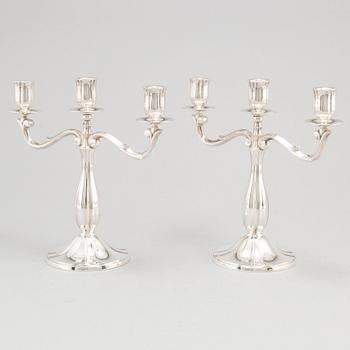 A pair of Swedish silver candelabra, makers mark GAB, Stockholm 1935 and 1938.