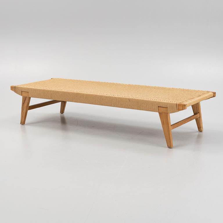 A contemporary teak daybed.