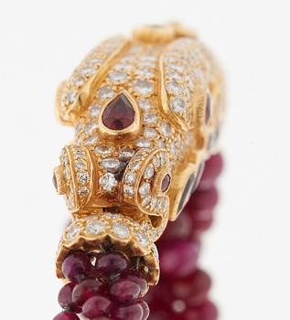 A Cartier chimera head bracelet in 18K gold set with round brilliant-cut diamonds and faceted rubies.