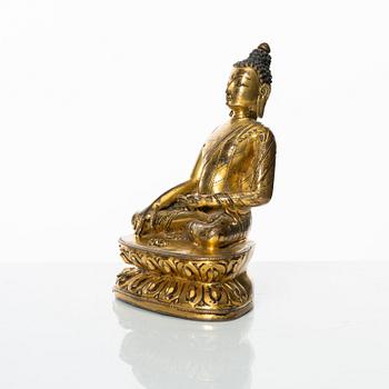 A gilt copper-alloy figure of Aksobhya Buddha, 14th/15th century, Tibet or Nepal.