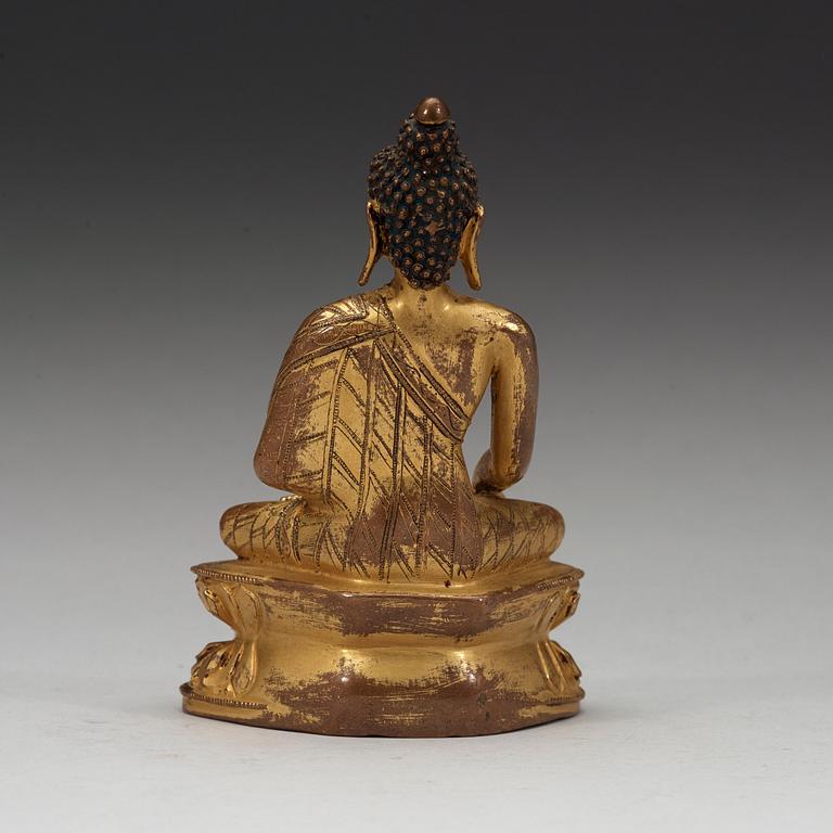A gilt copper-alloy figure of Aksobhya Buddha, 15th/16th century, Tibet or Nepal.