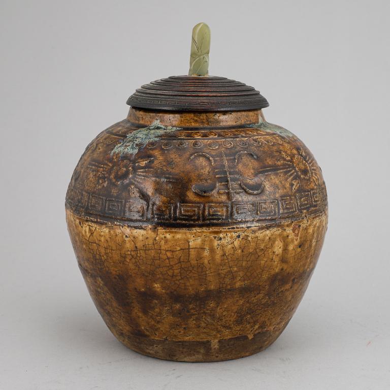 A ceramic glazed jar with wooden cover and a nephrite knob, Qing dynasty, 19th century.