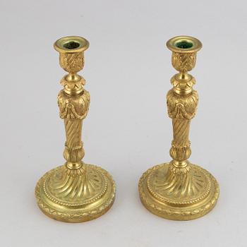 A pair of bronze Louis XV-style candlesticks, circa 1900.