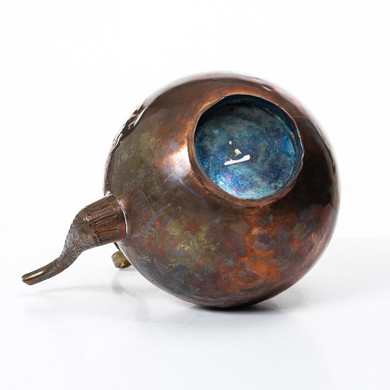 A German Rococo repoussé copper teapot on rechaud, mid 18th century.