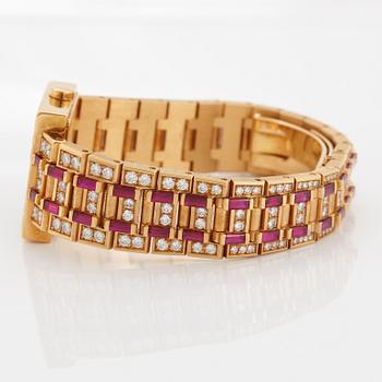 A Bulgari wristwatch in 18K gold set with step-cut rubies and round brilliant-cut diamonds.