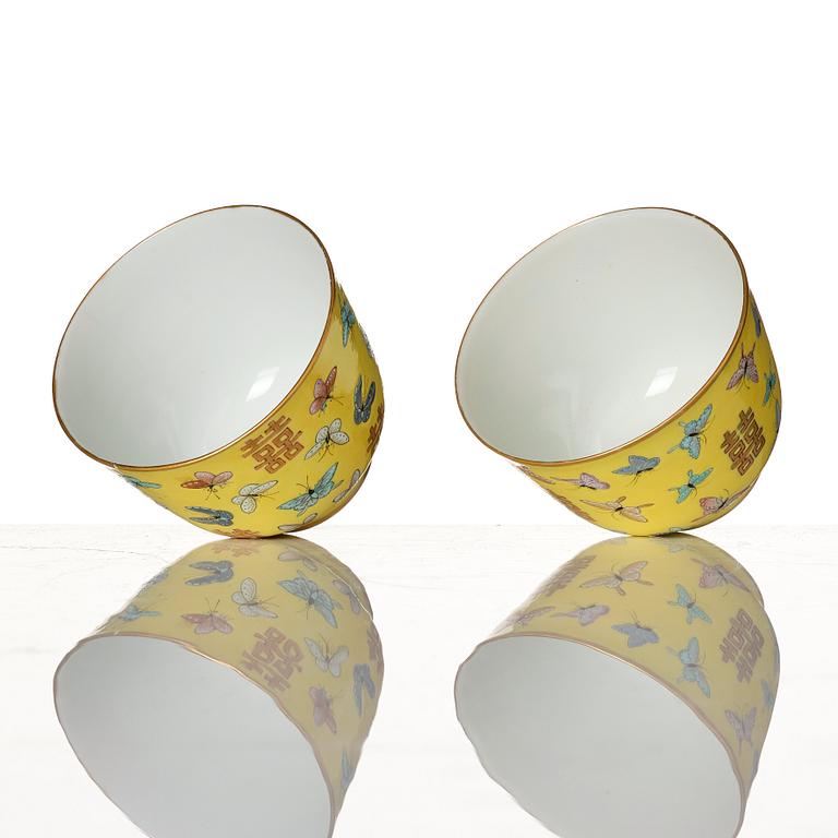 A pair of yellow glazed double happiness cups with butterflies, Qing dynasty, with Tongzhis four character mark to base.