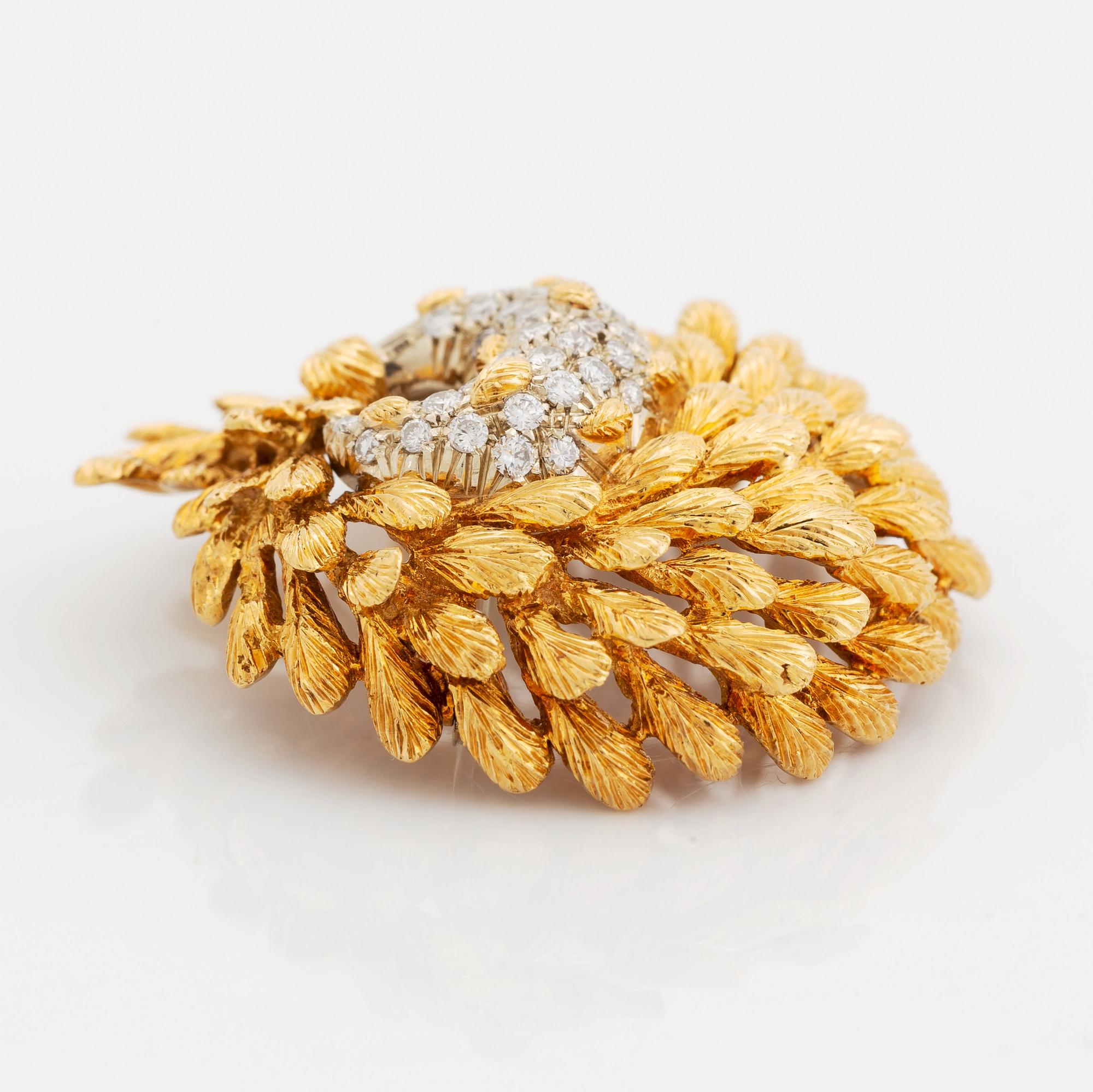 En brosch och ett par örhängen 18K guld med runda briljantslipade diamanter.