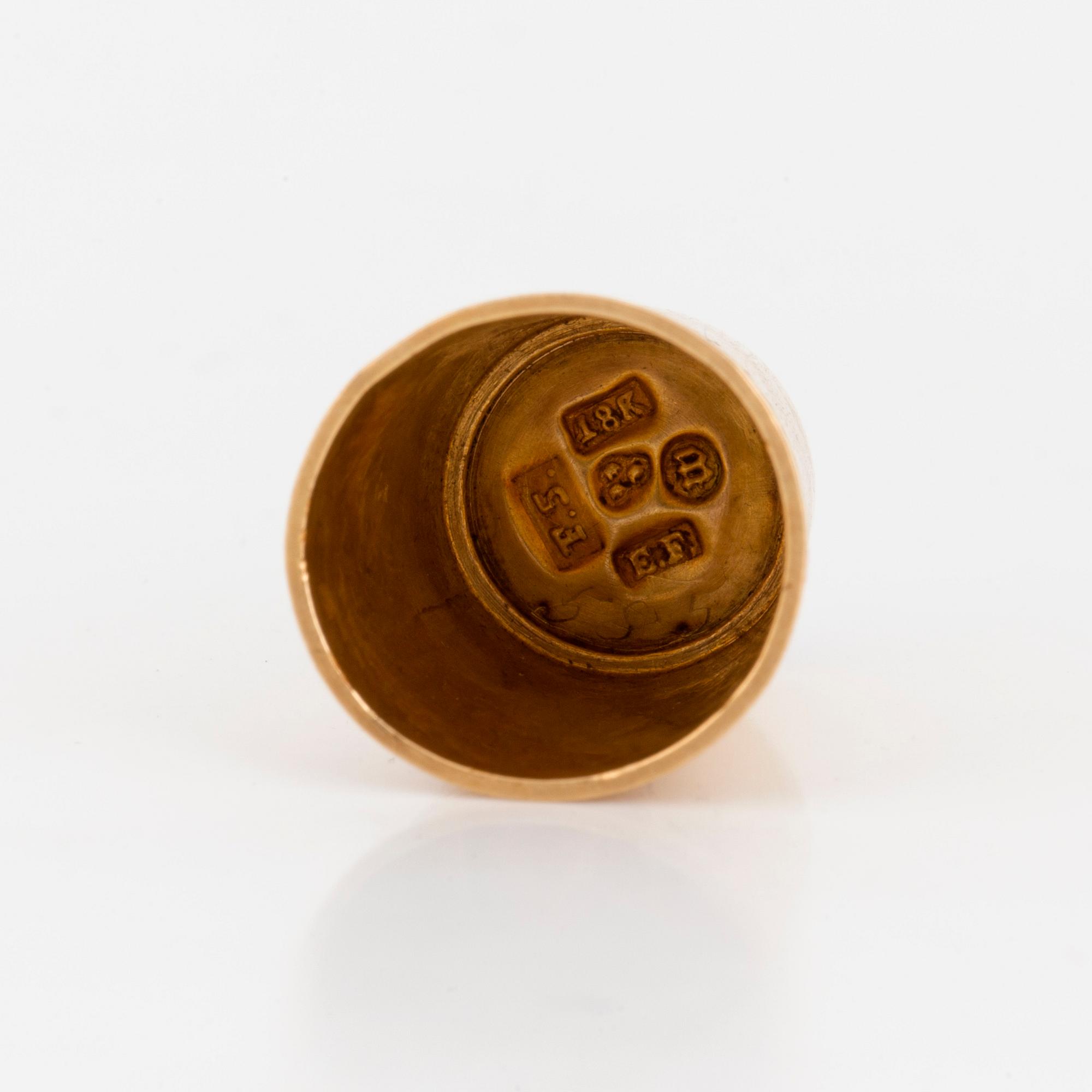 A thimble set with carnelian.