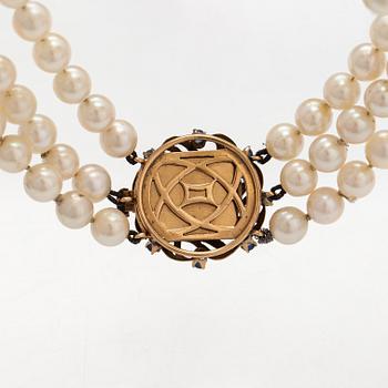 A three-strand pearl collier with cultured pearls and a 17K gold clasp with natural and synthetic sapphires.