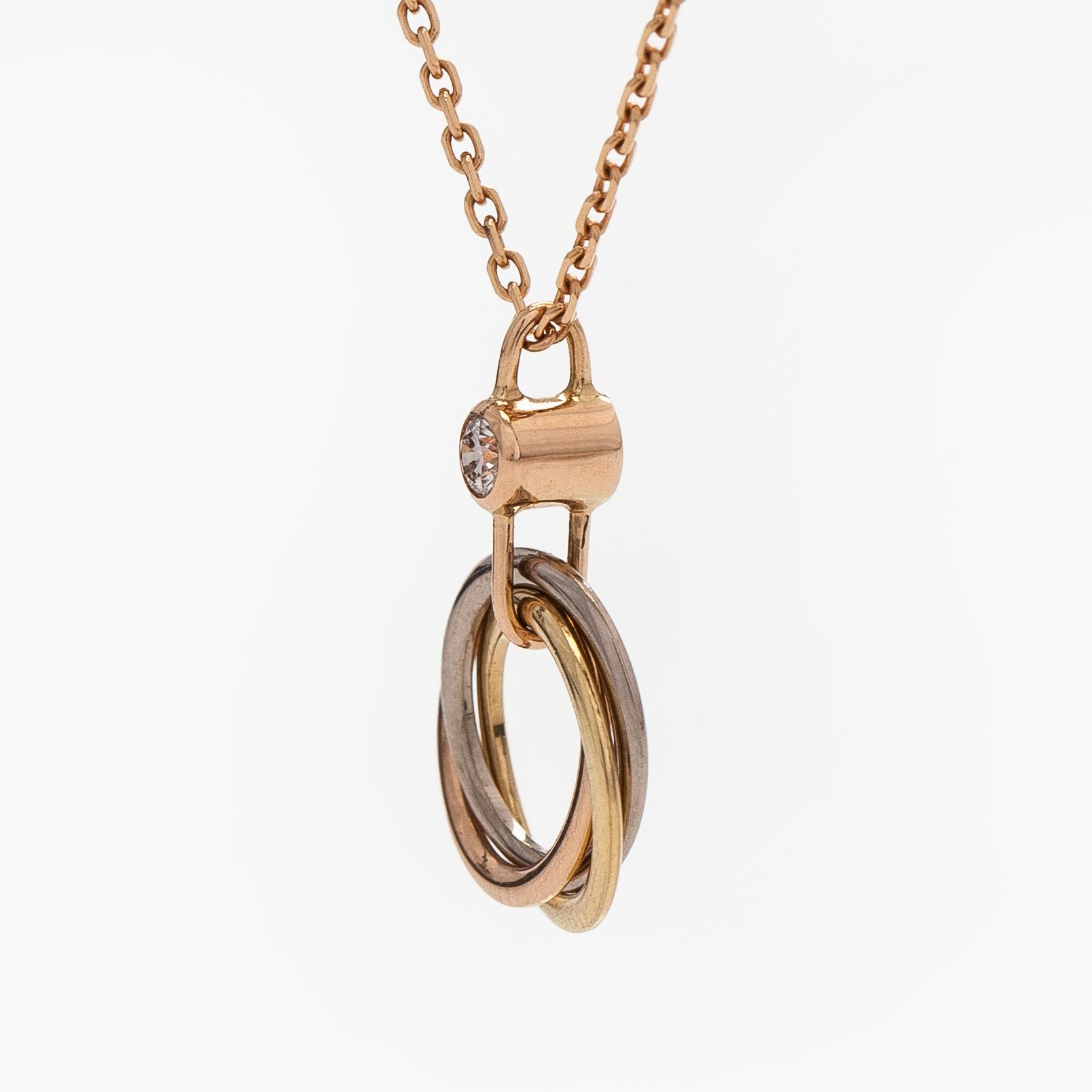 Cartier, an 18K gold 'Trinity Pendant' necklace with a brilliant-cut diamond.