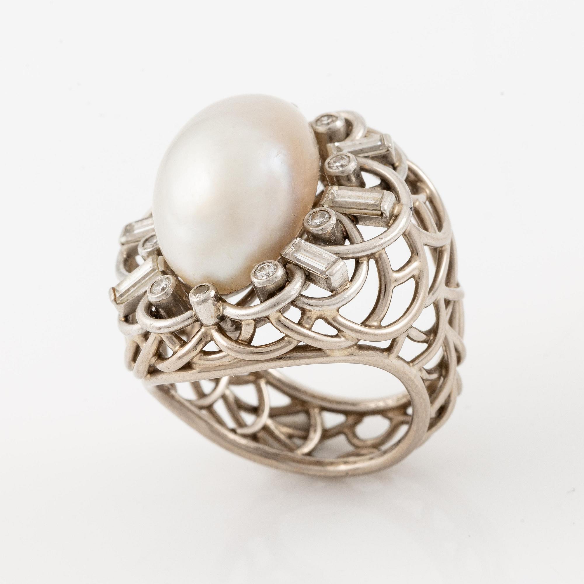 A ring in 18K gold with a cultured half pearl and diamonds in various cuts.