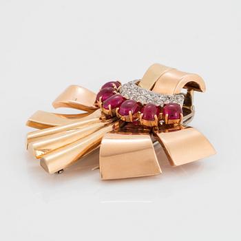 A 14K gold brooch set with cabochon-cut rubies and old-cut diamonds.