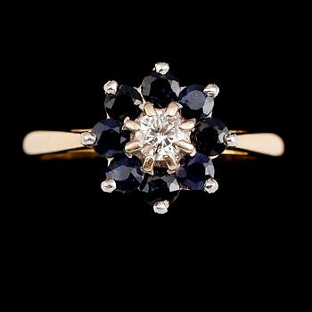 RING, 18 k guld med briljantslipad diamant samt 8 blå safirer. Total vikt ca 3 gram.