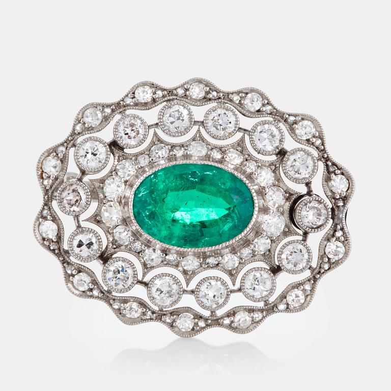 A platinum brooch set with a faceted emerald ca 3 cts and old- and eight-diamonds.