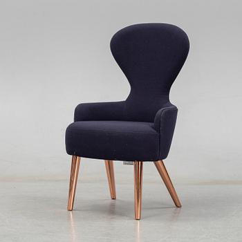 A Tom Dixon "Wingback Dining Chair" from Tom Dixon.