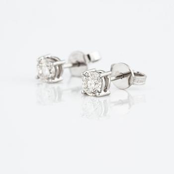 A pair of brilliant cut diamond earrings.