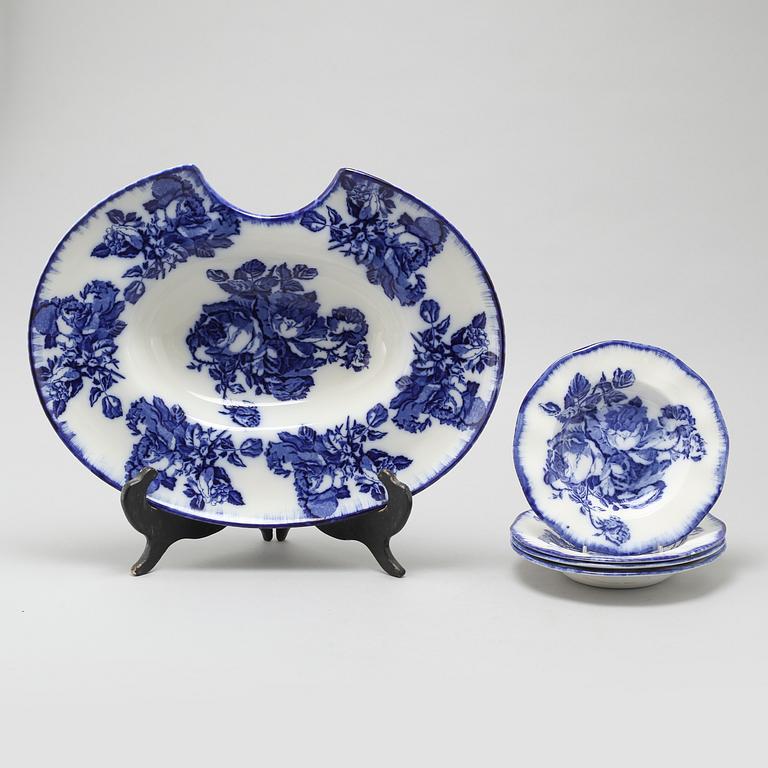 An eartheware shaving bowl and four soup plates from Staffordshire, England, around the year 1900.