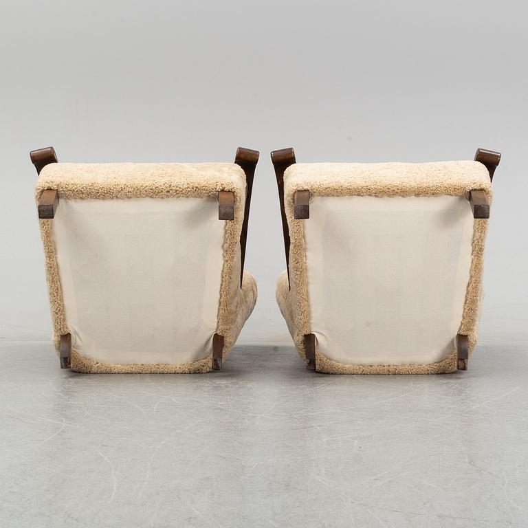A pair of Danish lounge chairs with sheepskin upholstery.