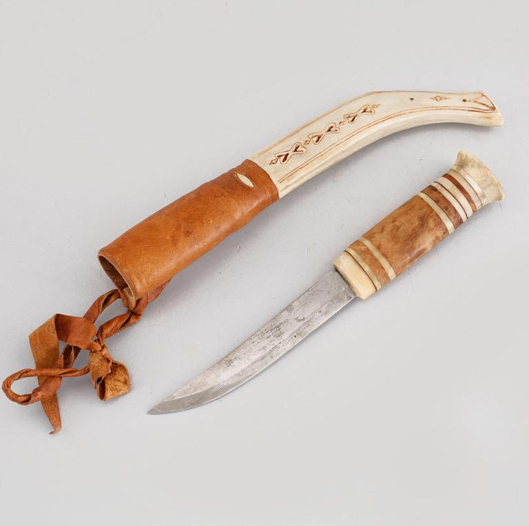 A Sami knife in antler, birch and leather, signed PU, carved dating 1975.