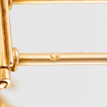 A Van Cleef & Arpels brooch in 18K gold with round brilliant-cut diamonds.