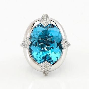 Pavé-set ring/cocktail ring in 18K white gold with an oval faceted blue topaz and round brilliant-cut diamonds.